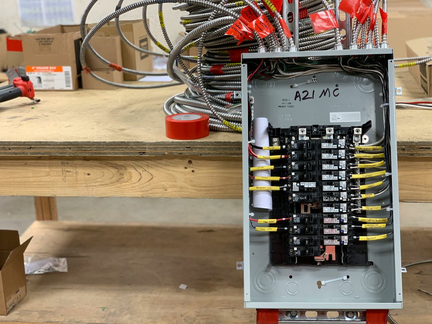 Quadro elettrico cablato su un banco da lavoro con tubi.